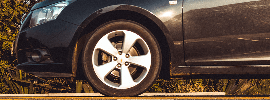 side view of black car showing headlight and front wheel